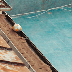 Low angle view of ball hanging on swimming pool against wall