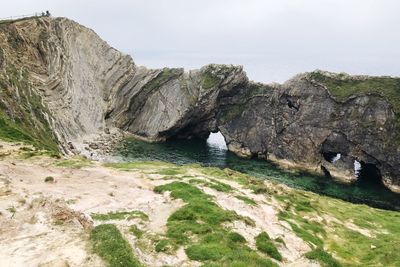 Rock formations by sea against sky