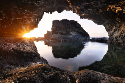 Rock formations by sea against sky