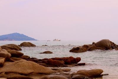 Rocks on beach against clear sky