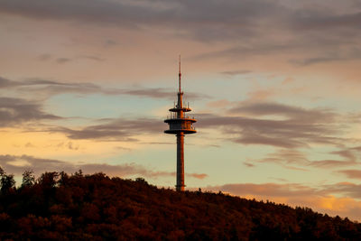 Low angle view of communications tower against sky during sunset