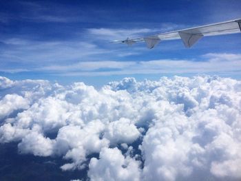 Airplane wing against cloudy sky