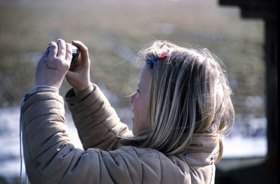 Close-up of girl photographing with digital camera during winter