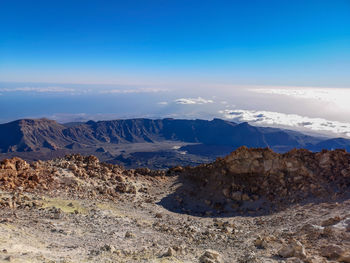 Scenic view of mountains against blue sky