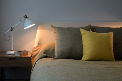 Electric lamp on sofa against wall at home