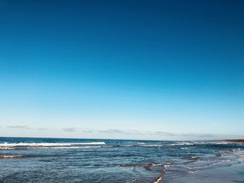 Scenic view of sea against clear blue sky