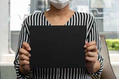 Midsection of man holding mobile phone