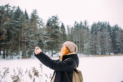 Rear view of woman standing in snow