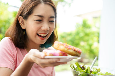 Portrait of smiling young woman eating food