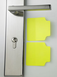 Close-up of yellow papers by lock on door
