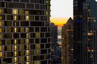 Illuminated buildings against sky at sunset