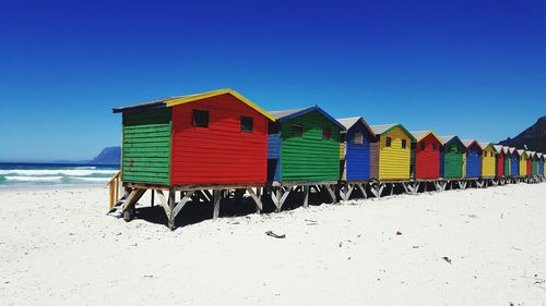 Multi colored umbrellas on beach against clear blue sky