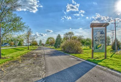 Road amidst trees against sky