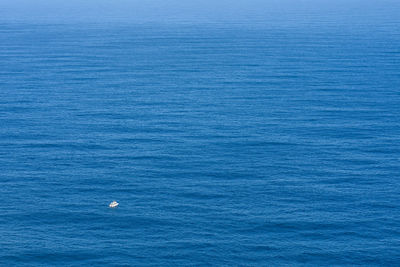 Small boat on a vast open ocean