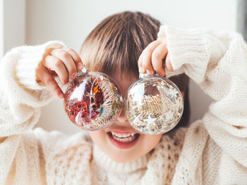 Kid with decorative balls for christmas tree. transparent balls with spangles inside. new year.