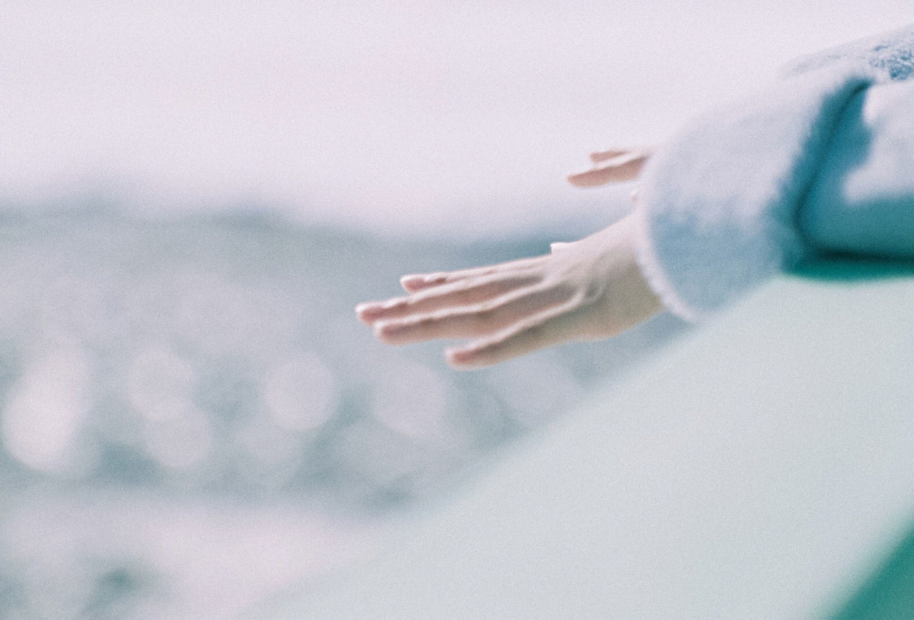 CLOSE-UP OF WOMAN HAND WITH BLURRED BACKGROUND