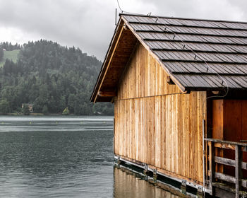 View of house by lake against sky