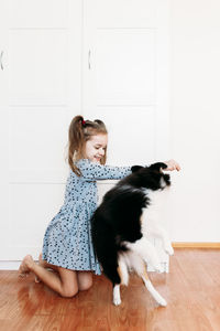 Woman with cat sitting on wooden floor