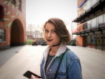 Portrait of beautiful woman standing in city