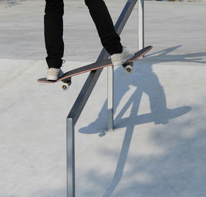 Low section of man skateboarding on street