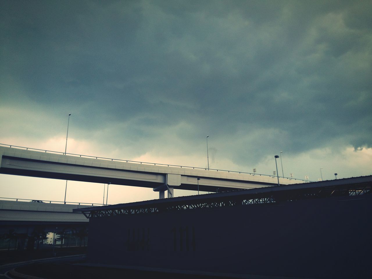 sky, low angle view, architecture, built structure, connection, transportation, building exterior, silhouette, cloud - sky, bridge - man made structure, cloudy, dusk, cloud, outdoors, city, street light, no people, building, overcast, day