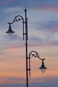 Low angle view of illuminated street light against sky