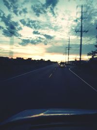 Road against cloudy sky at sunset