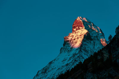 Low angle view of rock formation against clear blue sky