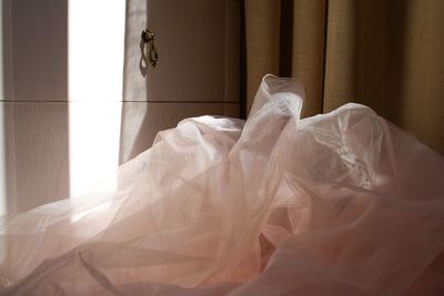 Close-up of clothes hanging on bed at home