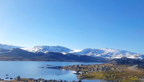 Scenic view of snowcapped mountains against clear blue sky