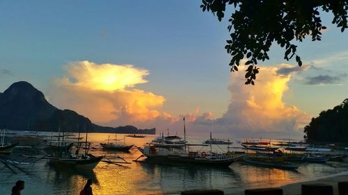 Boats in sea at sunset