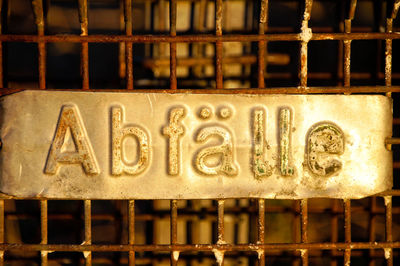 Close-up of text on metal rubbish container