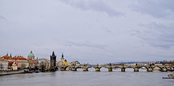 Bridge over river against buildings in city