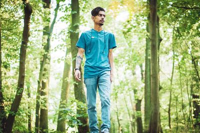 Young man looking away in forest