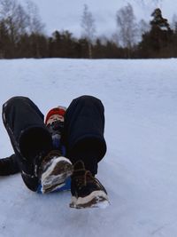 Low section of woman standing on snow covered field