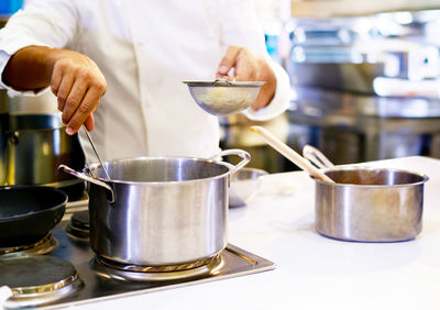 Midsection of man preparing food in kitchen