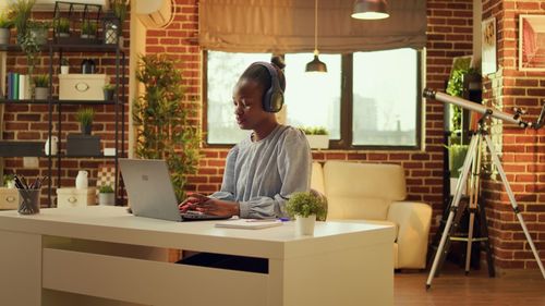 Young woman using laptop while sitting in cafe