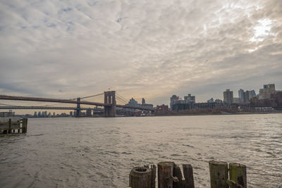 Bridge over sea and buildings against sky