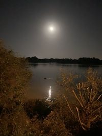 Scenic view of lake against sky at night