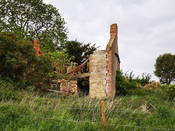 Abandoned built structure on field against sky