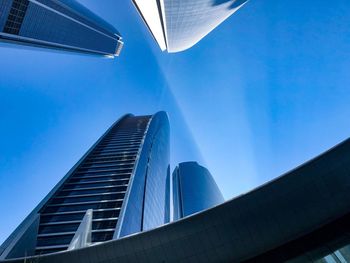 Low angle view of modern buildings against clear blue sky