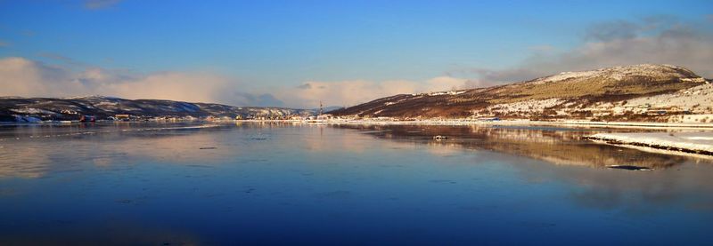 Scenic view of sea and mountains against sky