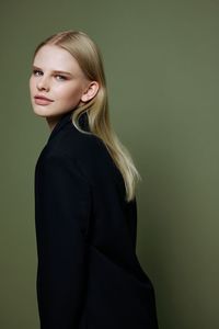 Young woman standing against gray background