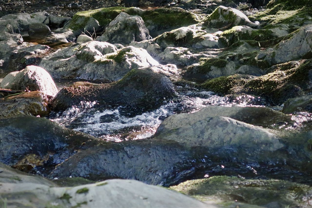 HIGH ANGLE VIEW OF RIVER FLOWING AMIDST ROCKS