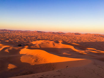 Scenic view of desert against sky during sunset