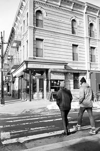 Rear view of woman walking in front of building