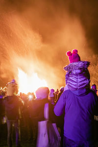 People watching bonfire at night