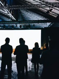 Rear view of silhouette men standing in corridor