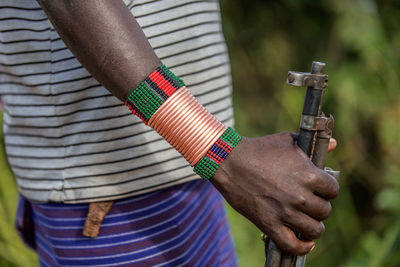 Midsection of man holding gun