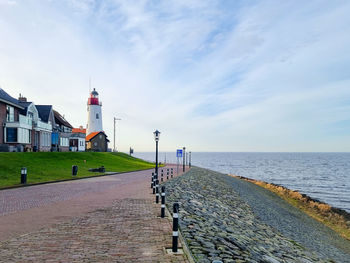 Scenic view of sea by buildings against sky